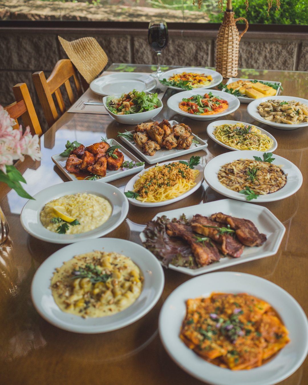 Mesa da Casa Fracalossi servida com massas, risotos, carnes e saladas da sequência italiana